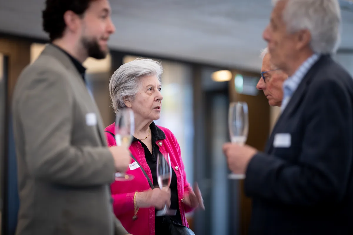 Mehrere Personen stehen zusammen und diskutieren. 
